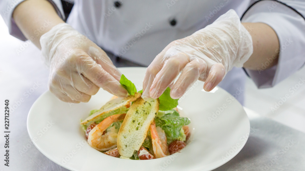 Chef preparing Caesar salad with shrimps Chef preparing Caesar salad with shrimps