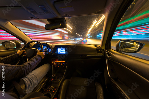 Driving in the night landscape, hands on the wheel. Raindrops. © narozhnii