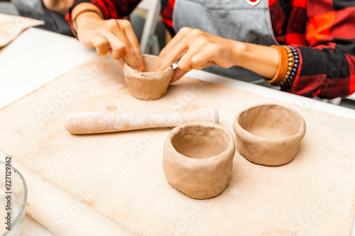 Young woman create clay and ceramic art dishes in pottery workshop