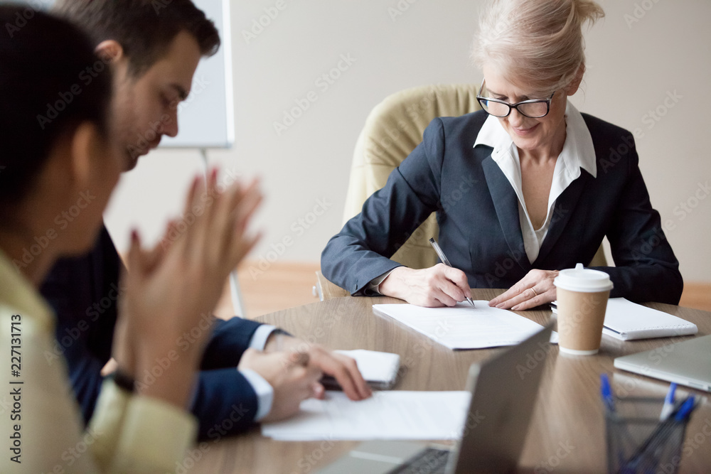 Business partners sign agreement in office after successful boardroom meeting, middle aged employee put signature on contract, closing deal at briefing or negotiation, colleagues legalize cooperation Business partners sign agreement in office after successful boardroom meeting, middle aged employee put signature on contract, closing deal at briefing or negotiation, colleagues legalize cooperation