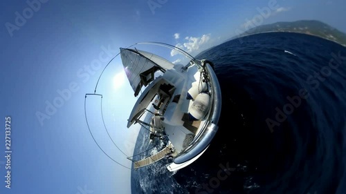 Sailboat catamaran sailing offshore in a sunny day. A man relaxing at the stern. A VR360 Effect