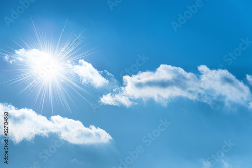 Sun with sun rays on the blue sky with clouds