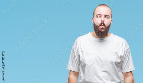 Young caucasian hipster man wearing casual t-shirt over isolated background making fish face with lips, crazy and comical gesture. Funny expression.