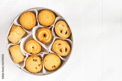 Different shortbread cookies in a box on white, top view.