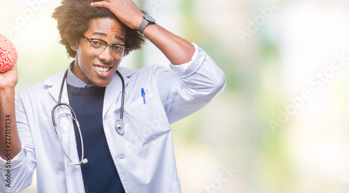 Afro american neurologist doctor or psychology man over isolated background stressed with hand on head, shocked with shame and surprise face, angry and frustrated. Fear and upset for mistake.