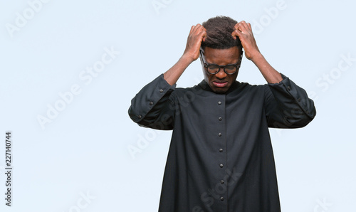 Fotografie Young african american priest man over isolated background suffering from headache desperate and stressed because pain and migraine