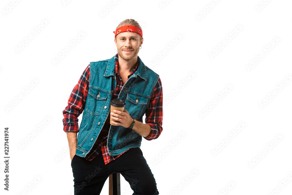 smiling man in headband and denim vest sitting on chair with coffee cup isolated on white smiling man in headband and denim vest sitting on chair with coffee cup isolated on white