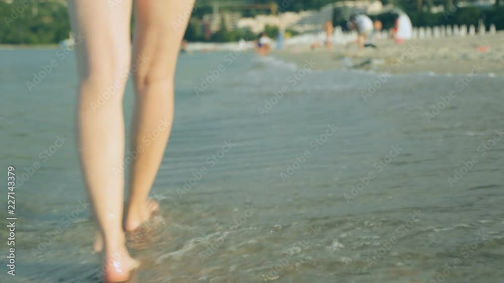 Woman walking along coast in summer day Woman walking along coast in summer day