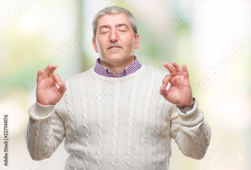 Handsome senior man wearing winter sweater over isolated background relax and smiling with eyes closed doing meditation gesture with fingers. Yoga concept.