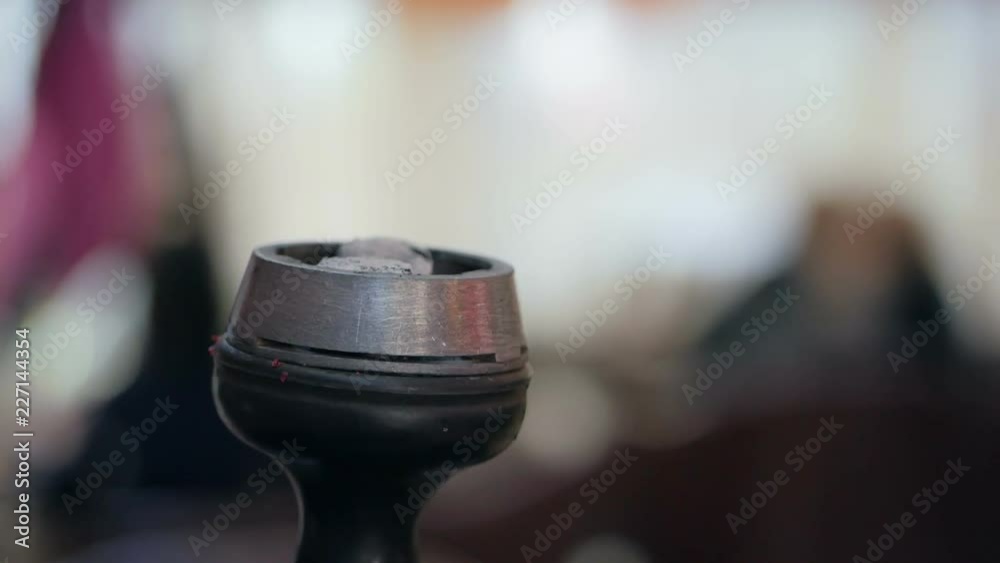 Hookah close-up. A man's hand puts coal in a hookah. Hookah close-up. A man's hand puts coal in a hookah.