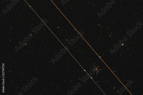 Poorly outlined planes parts against the background of the night sky and galaxies