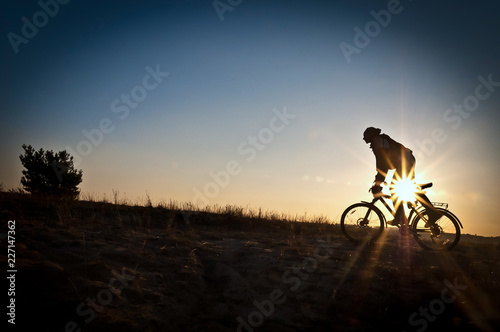 Silhouette of the cyclist speed riding on sunset