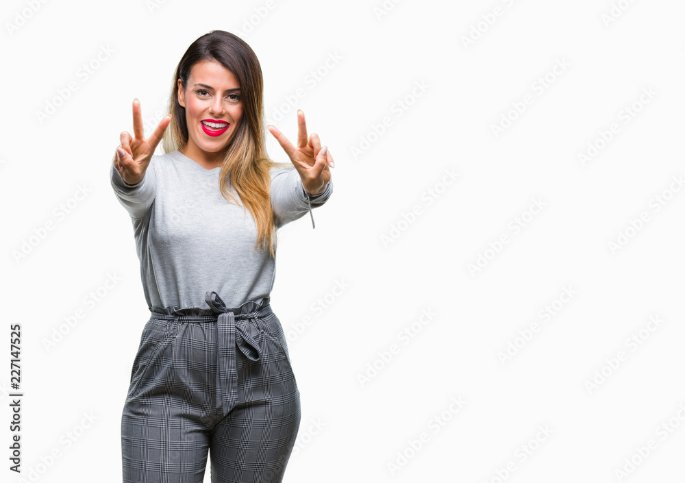 Obraz premium Young beautiful worker business woman over isolated background smiling looking to the camera showing fingers doing victory sign. Number two.