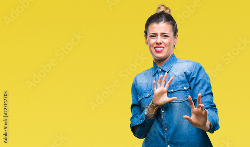 Young beautiful woman over isolated background disgusted expression, displeased and fearful doing disgust face because aversion reaction. With hands raised. Annoying concept.