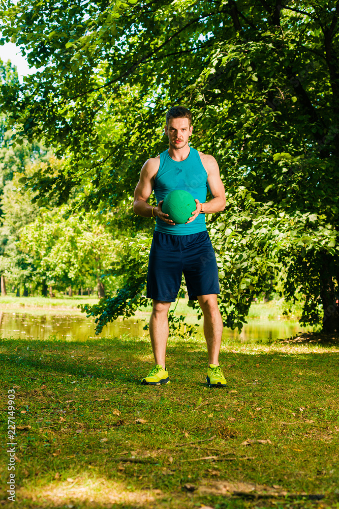 Fitness man in the park doing workout with the ball Fitness man in the park doing workout with the ball