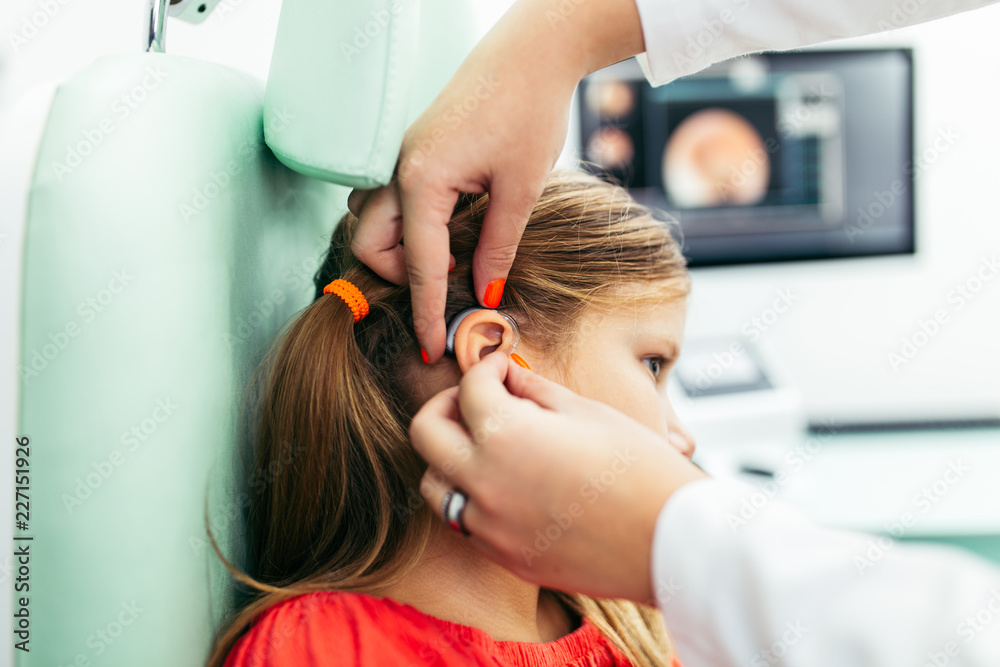 Young girl at medical examination or hearing aid checkup in otolaryngologist's office Young girl at medical examination or hearing aid checkup in otolaryngologist's office