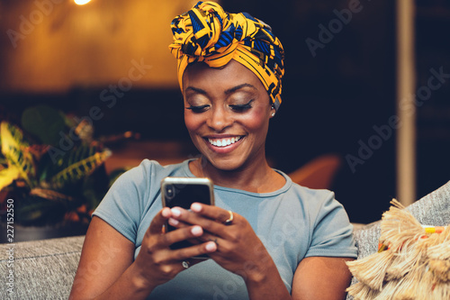 African American Woman wearing headscarf using smartphone - colorful photo