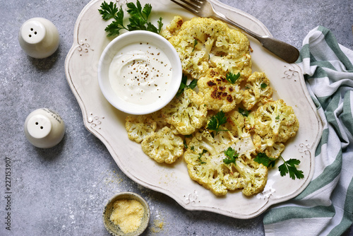 Oven baked cauliflower with cream garlic sauce.Top view with copy space.