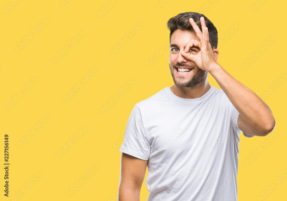 Young handsome man over isolated background doing ok gesture with hand smiling, eye looking through fingers with happy face. Young handsome man over isolated background doing ok gesture with hand smiling, eye looking through fingers with happy face.