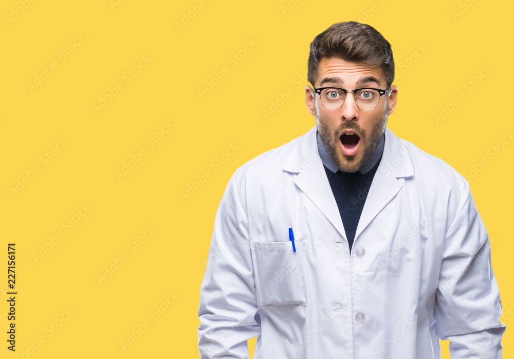 Young handsome man wearing doctor, scientis coat over isolated background afraid and shocked with surprise expression, fear and excited face. Young handsome man wearing doctor, scientis coat over isolated background afraid and shocked with surprise expression, fear and excited face.