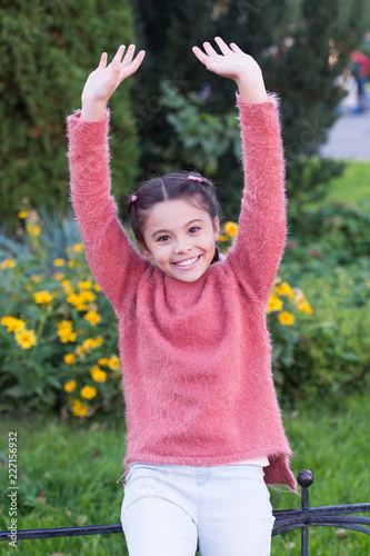 Active little girl playing outdoors and having fun. Positive small girl jumping. Interactive outdoor games. Pretty little girl keeping fit and healthy. Spending time in park. Enjoying nature