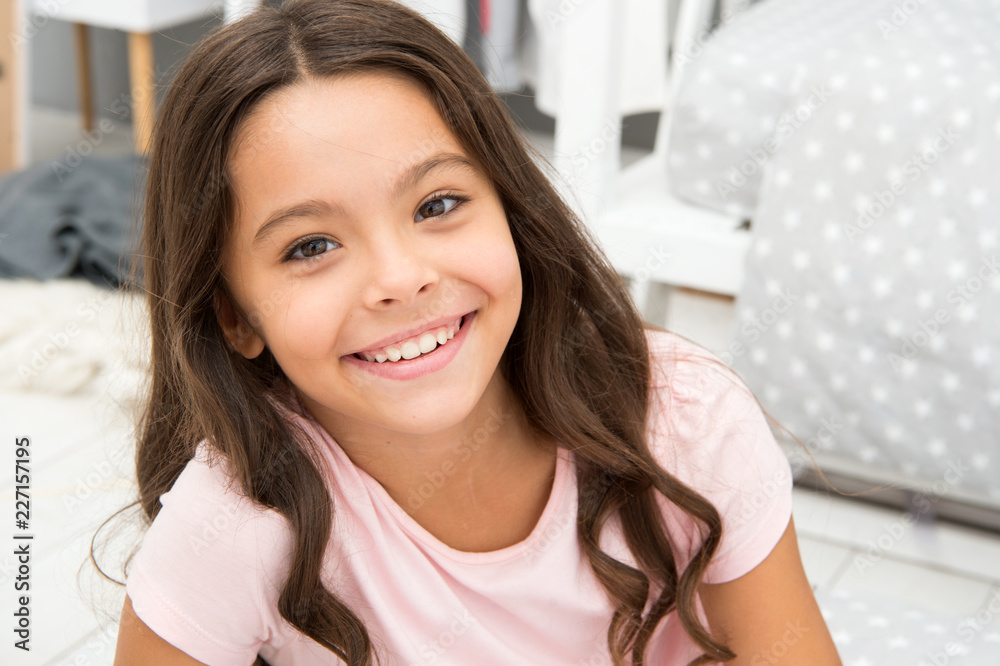 Girl child in bedroom. Kid smiling prepare go to bed. Pleasant time relax cozy bedroom. Girl kid long hair cute pajamas relaxing before sleep. Time to sleep or nap. Wish her sweet dreams