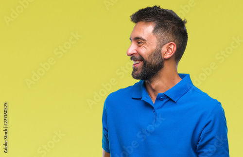 Adult hispanic man over isolated background looking away to side with smile on face, natural expression. Laughing confident. © Krakenimages.com
