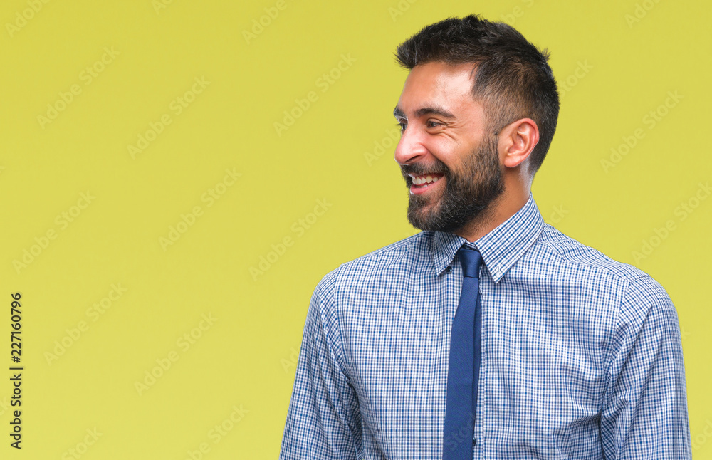 Adult hispanic business man over isolated background looking away to side with smile on face, natural expression. Laughing confident. Adult hispanic business man over isolated background looking away to side with smile on face, natural expression. Laughing confident.