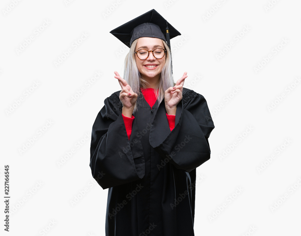 Young blonde woman wearing graduate uniform over isolated background smiling crossing fingers with hope and eyes closed. Luck and superstitious concept. Young blonde woman wearing graduate uniform over isolated background smiling crossing fingers with hope and eyes closed. Luck and superstitious concept.