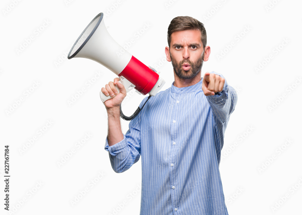 Young handsome man yelling through megaphone over isolated background pointing with finger to the camera and to you, hand sign, positive and confident gesture from the front Young handsome man yelling through megaphone over isolated background pointing with finger to the camera and to you, hand sign, positive and confident gesture from the front