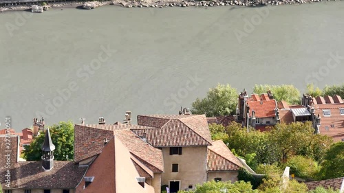 Shadow of the cable cars in the water of the Isère river in Grenoble. Grenoble is located in southeastern France. Roofs of houses in the foreground.