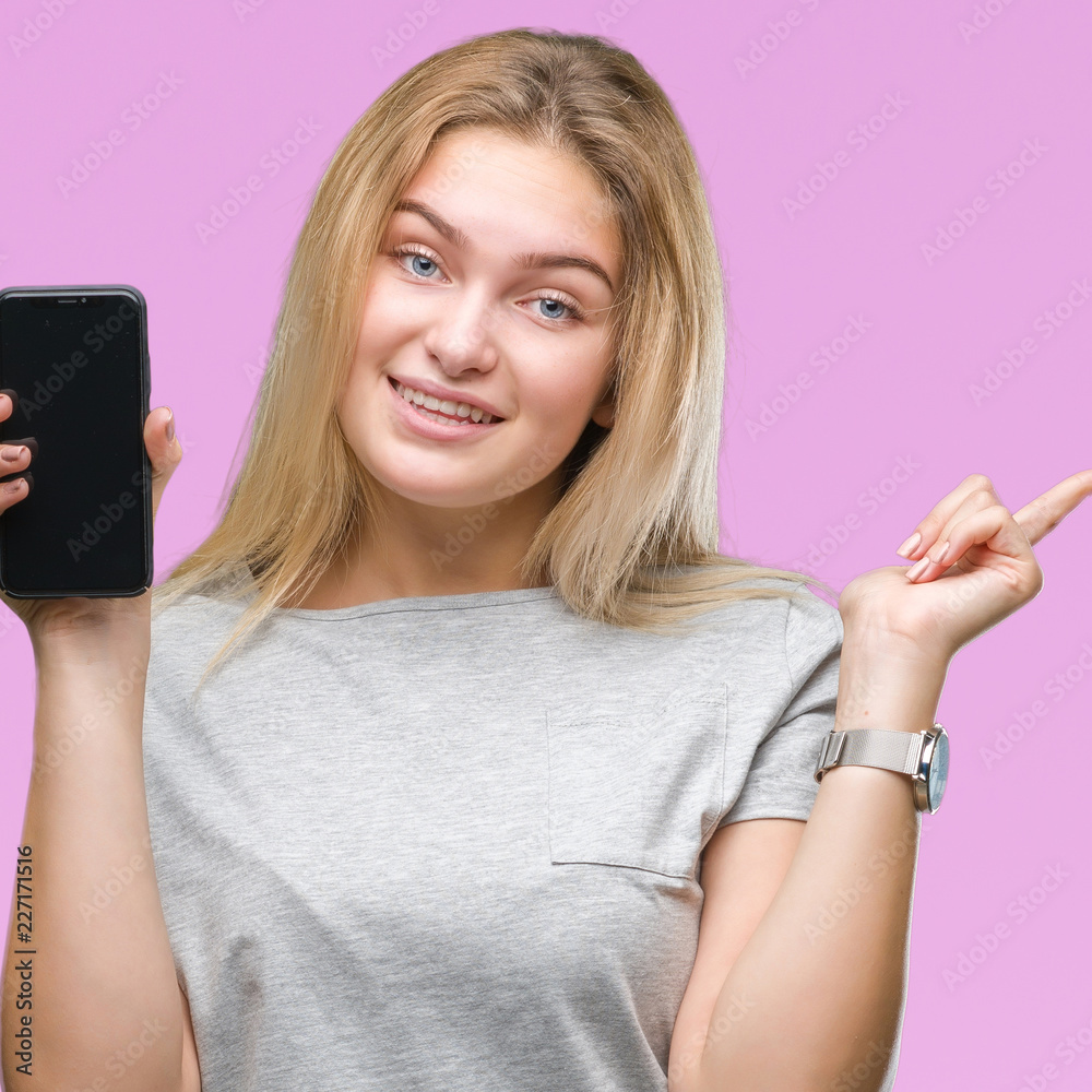 Young caucasian woman showing screen of smartphone over isolated background very happy pointing with hand and finger to the side Young caucasian woman showing screen of smartphone over isolated background very happy pointing with hand and finger to the side