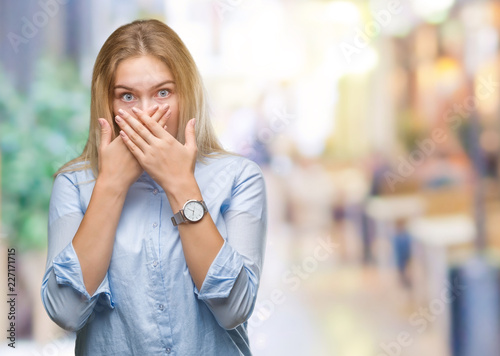 Young caucasian business woman over isolated background shocked covering mouth with hands for mistake. Secret concept.