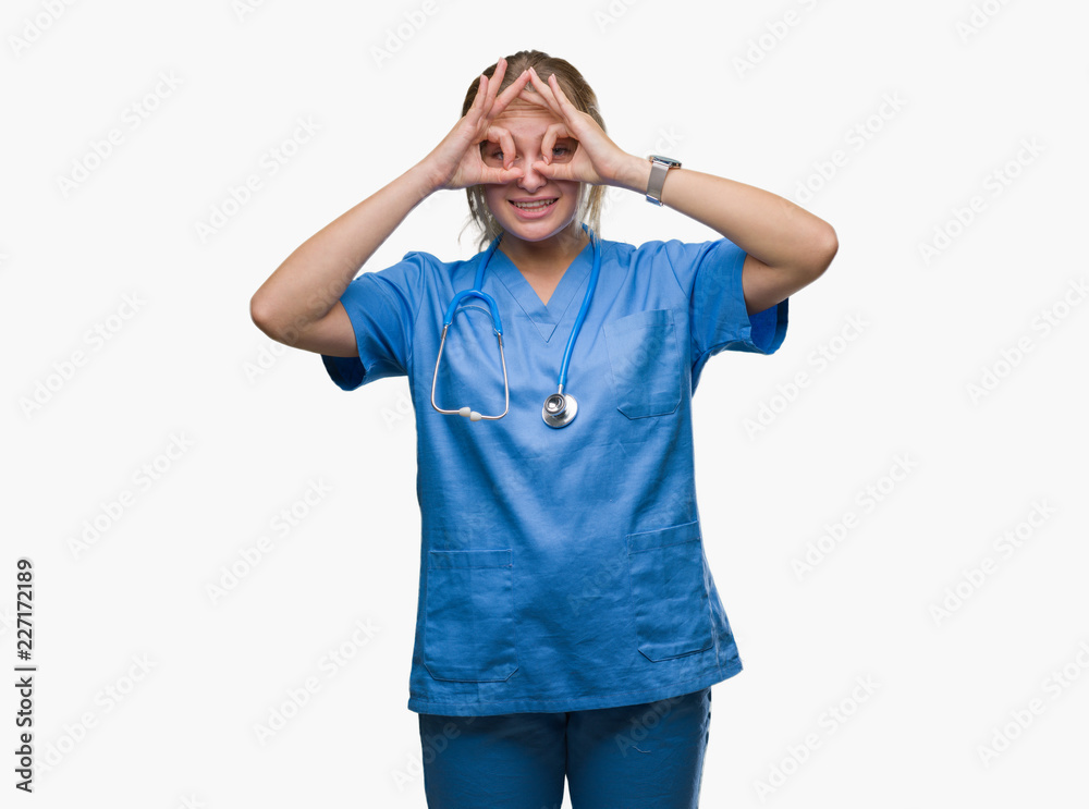 Young caucasian doctor woman wearing surgeon uniform over isolated background doing ok gesture like binoculars sticking tongue out, eyes looking through fingers. Crazy expression. Young caucasian doctor woman wearing surgeon uniform over isolated background doing ok gesture like binoculars sticking tongue out, eyes looking through fingers. Crazy expression.