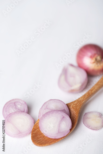 Sliced red shallot onion on wooden spoon, herb and spice, food ingredient