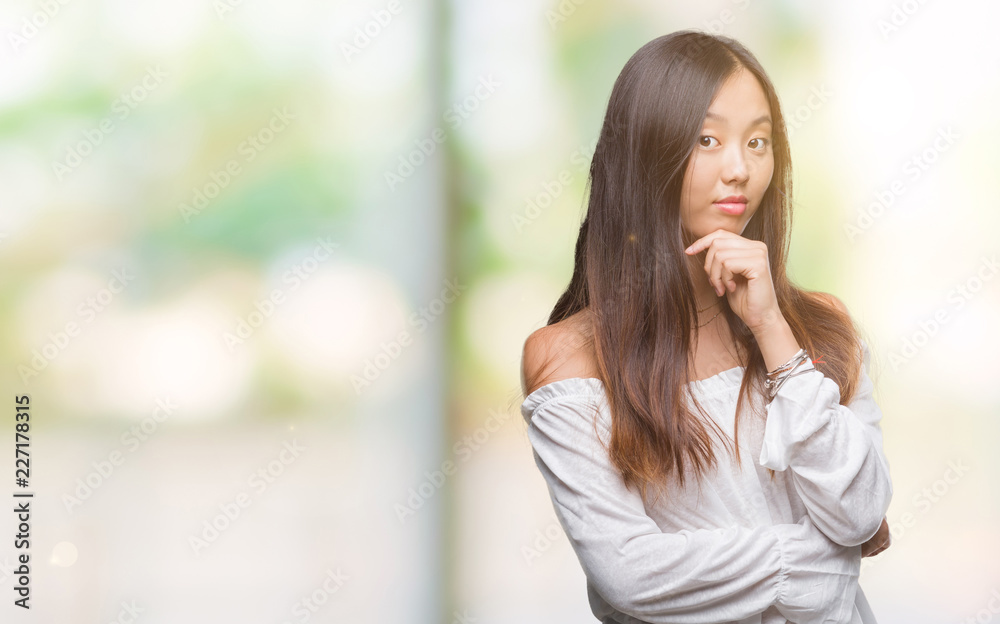 Young asian woman over isolated background looking confident at the camera with smile with crossed arms and hand raised on chin. Thinking positive. Young asian woman over isolated background looking confident at the camera with smile with crossed arms and hand raised on chin. Thinking positive.
