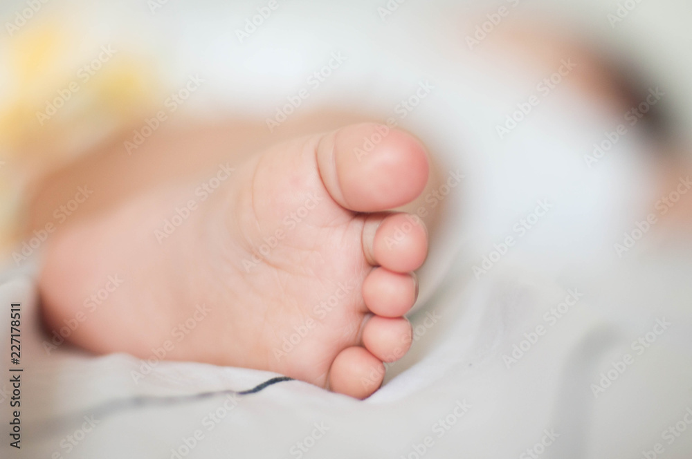 Isolated baby foot on white bed 