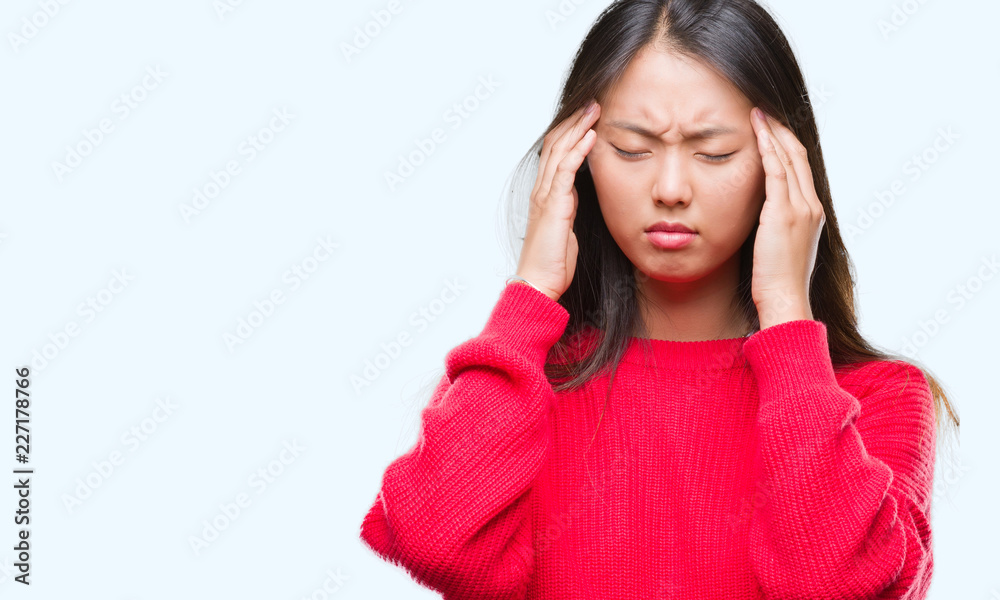Young asian woman wearing winter sweater over isolated background with hand on head for pain in head because stress. Suffering migraine. Young asian woman wearing winter sweater over isolated background with hand on head for pain in head because stress. Suffering migraine.
