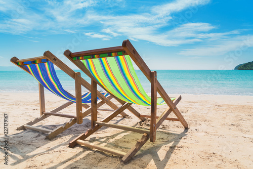 Two beach chairs on the white sand with blue sky and summer sea background. Summer  Vacation  Travel and Holiday concept.