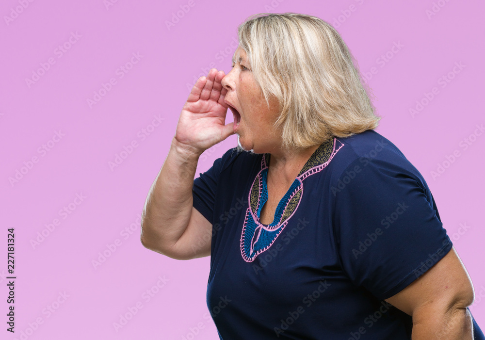 Senior plus size caucasian woman over isolated background shouting and screaming loud to side with hand on mouth. Communication concept. Senior plus size caucasian woman over isolated background shouting and screaming loud to side with hand on mouth. Communication concept.