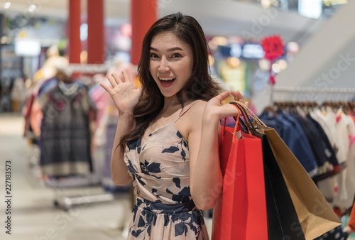 surprise woman with shopping bags in clothes store