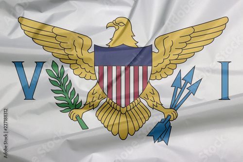Fabric flag of Virgin Islands. Crease of Virgin Islands flag background, the coat of arms of the United States between the letters V and I.