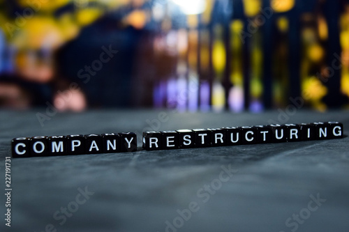 Company restructuring on wooden blocks. Business and finance concept. Cross processed image with bokeh background