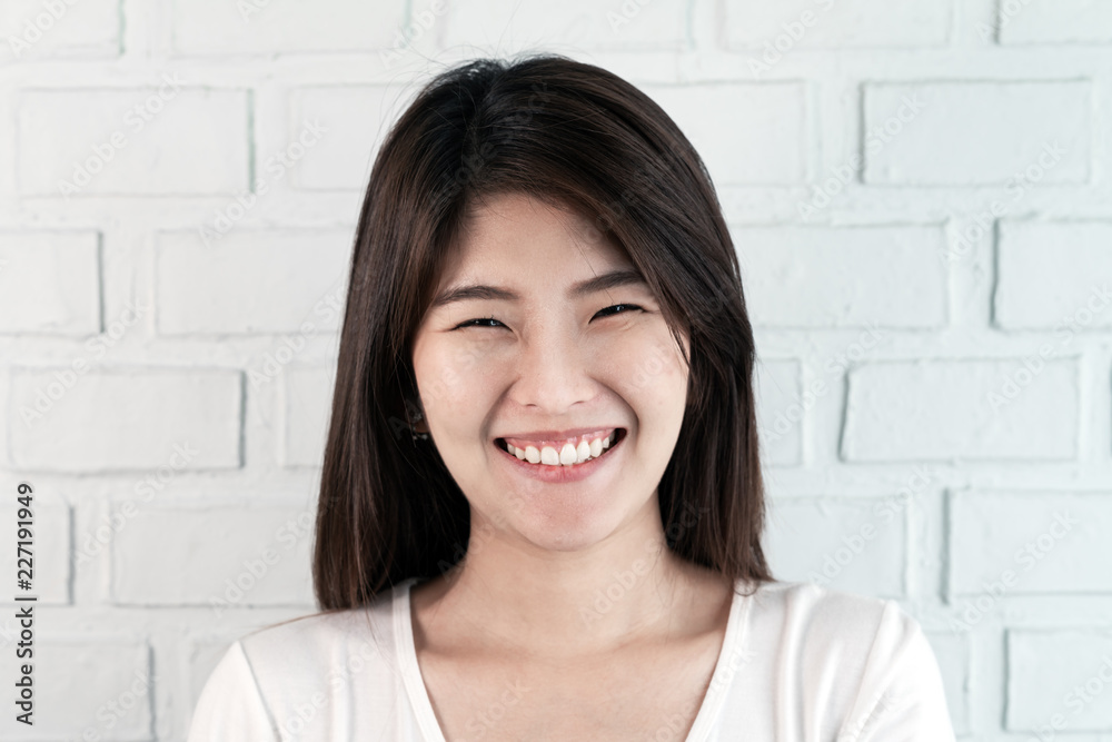 Portrait of young attractive asian brunette woman looking at camera smiling with confident and positve lifestyle concept on brick background at studio. Natural makeup look of young girl or student. Portrait of young attractive asian brunette woman looking at camera smiling with confident and positve lifestyle concept on brick background at studio. Natural makeup look of young girl or student.