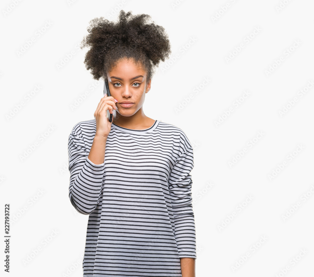 Young afro american woman talking on the phone over isolated background with a confident expression on smart face thinking serious Young afro american woman talking on the phone over isolated background with a confident expression on smart face thinking serious