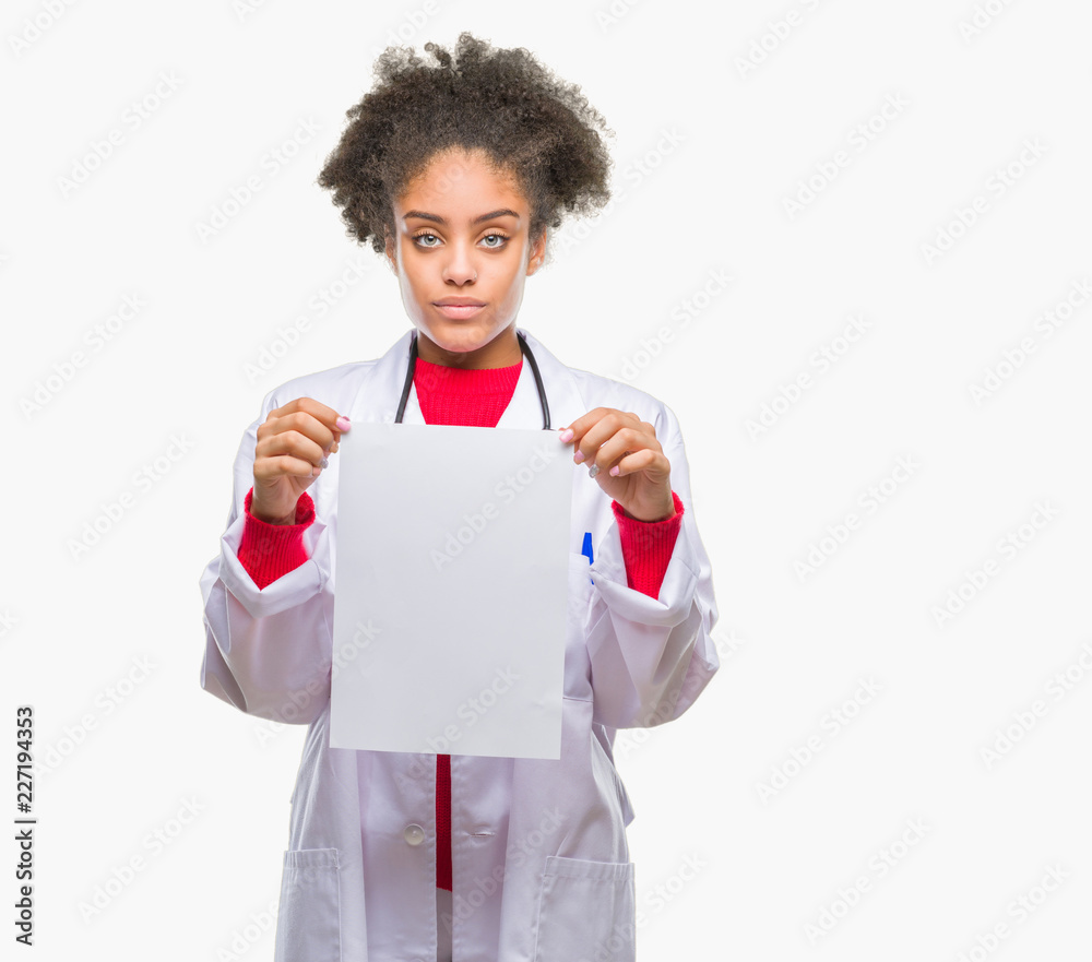 Young afro american doctor woman holding blank paper over isolated background with a confident expression on smart face thinking serious Young afro american doctor woman holding blank paper over isolated background with a confident expression on smart face thinking serious
