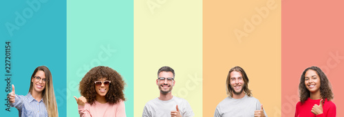 Collage of group of young people over colorful vintage isolated background doing happy thumbs up gesture with hand. Approving expression looking at the camera with showing success.