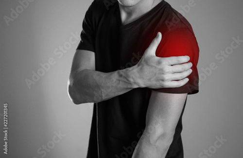 A man holding hands. Shoulder pain. The hearth is highlighted in red. Close up. Isolated background