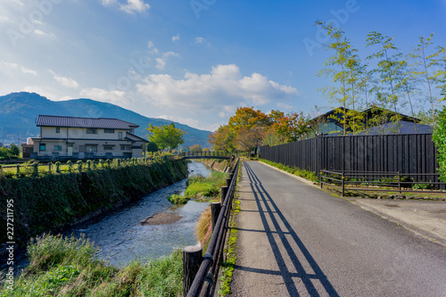 The View of Oita river flowing through Yufuin city with Mount Yufu in Background and blue sky with clouds in autumn. onsen town, Yufuin, Oita, Kyushu, Japan photo