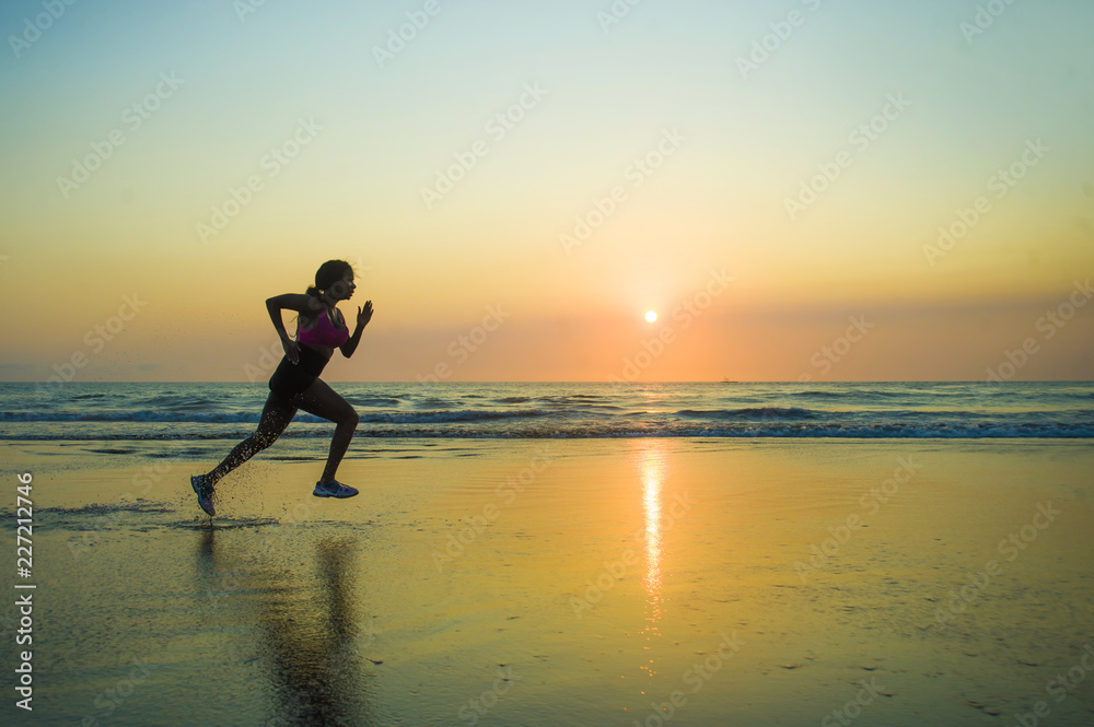 silhouette of young happy and attractive African American runner woman exercising in running fitness sprint workout at beautiful beach jogging and enjoying sunset